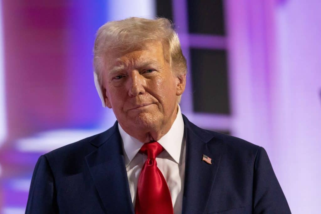 Donald Trump de terno e olhando ligeiramente para o lado