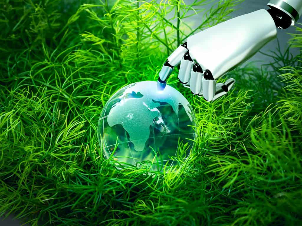 Mão de robô tocando um holograma da Terra apoiado em um gramado