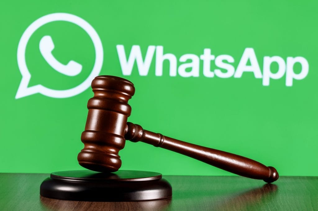 Martelo de juiz apoiado com logo do WhatsApp no fundo