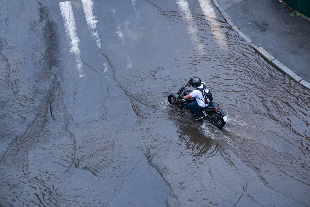 Motoqueiro andando de moto na chuva