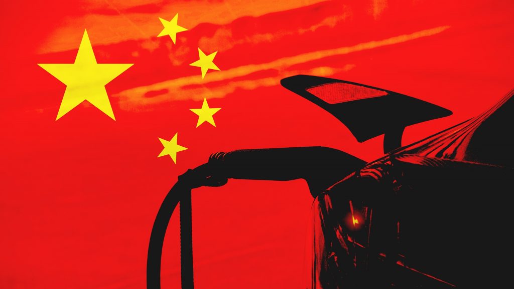 Bandeira da China ao fundo, com a sombra de um carro elétrico sendo carregado