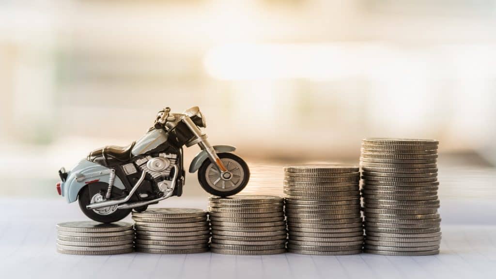 Mini modelo de motocicleta na pilha de moedas. Economia, Finanças, Empréstimo e Leasing Conceito.