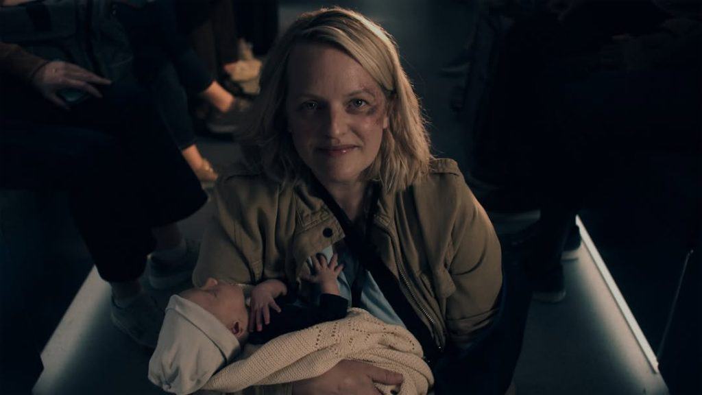 Mulher loira segurando bebe na série The Handmaid’s Tale