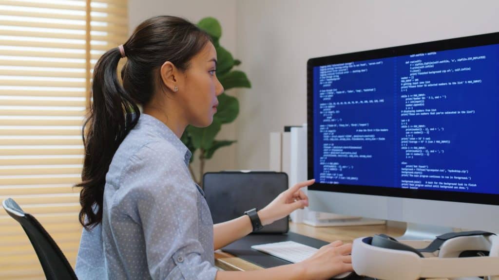 Desenvolvedora de plataforma de aplicativos para o Metaverso, trabalho de habilidades futuras para o setor de tecnologia, jovem mulher asiática trabalha em casa usando um headset de realidade virtual, realizando testes de jogos em segurança cibernética, computação em nuvem e soluções web.