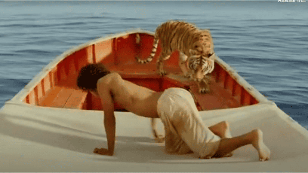 Menino de calça branca com tigre em um barco no meio do oceano