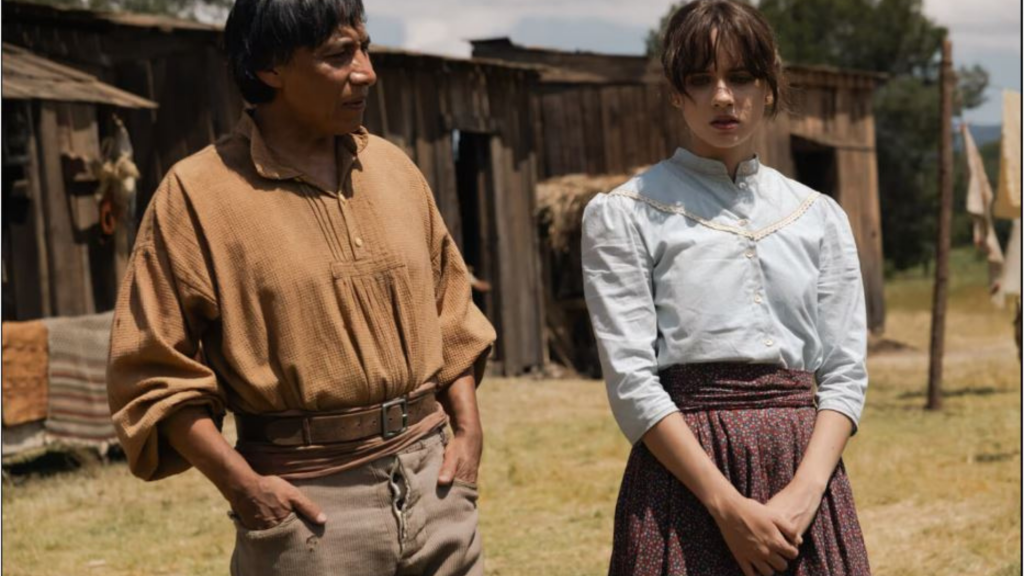 Homem com a mão no bolso e mulher com mãos cruzadas na frente das pernas (ambos estão em pé e usam roupas mexicanas de fazenda)