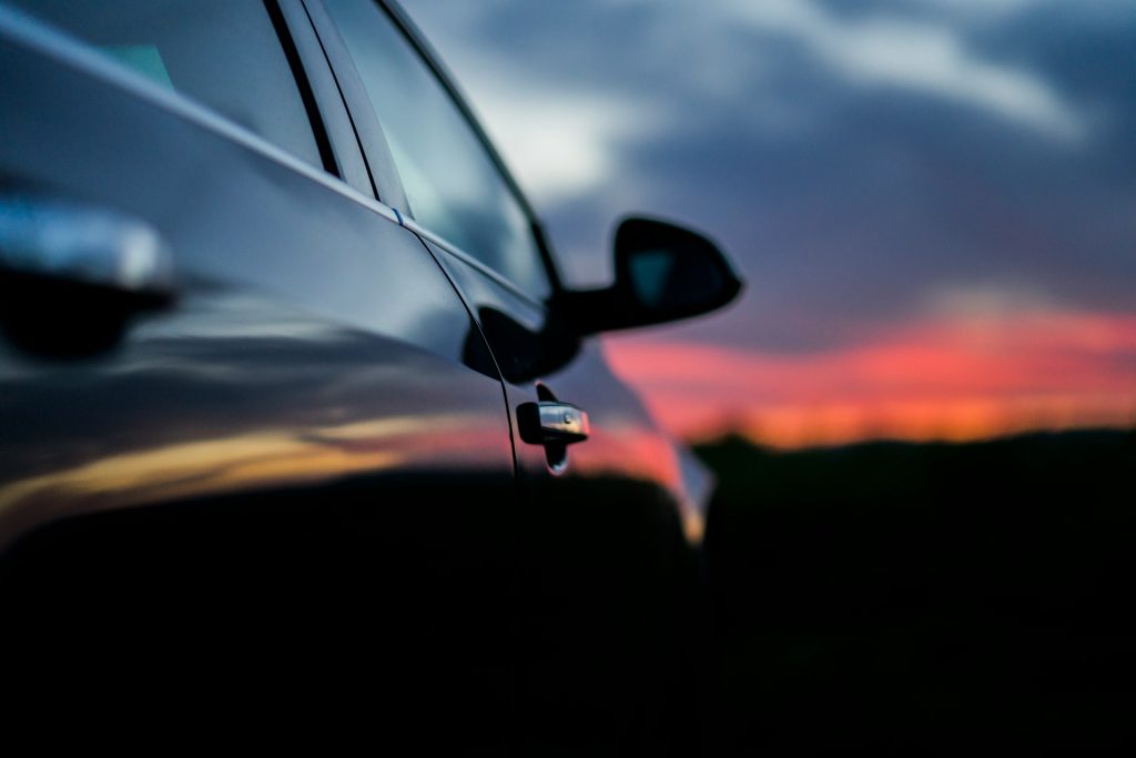 Porta fechada de um carro com um pr do sol no fundo