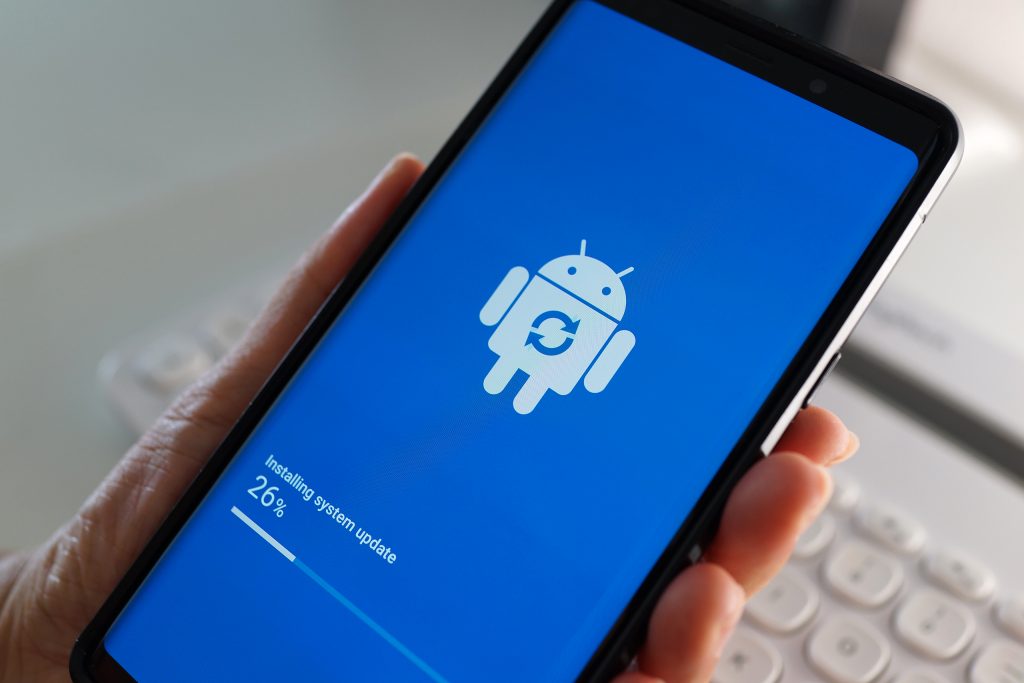 Pessoa segurando um smartphone com Android que está sendo atualizado