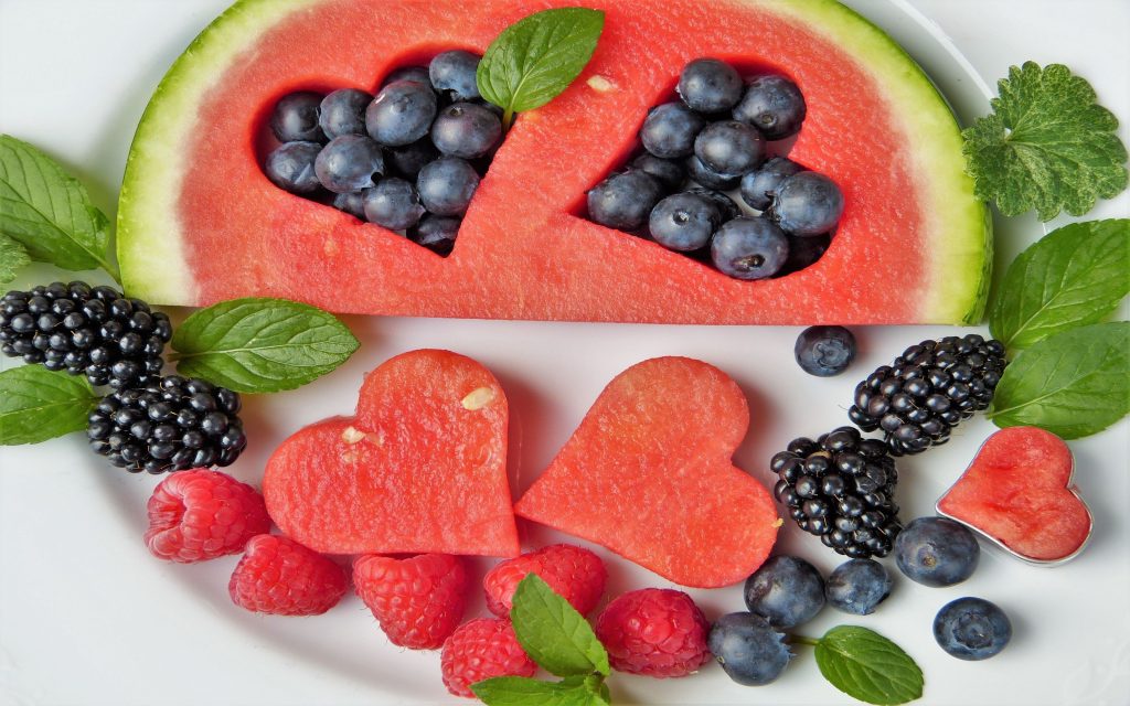 Imagem mostra frutas como melancia, amoras e mirtilos cortados em forma de corações