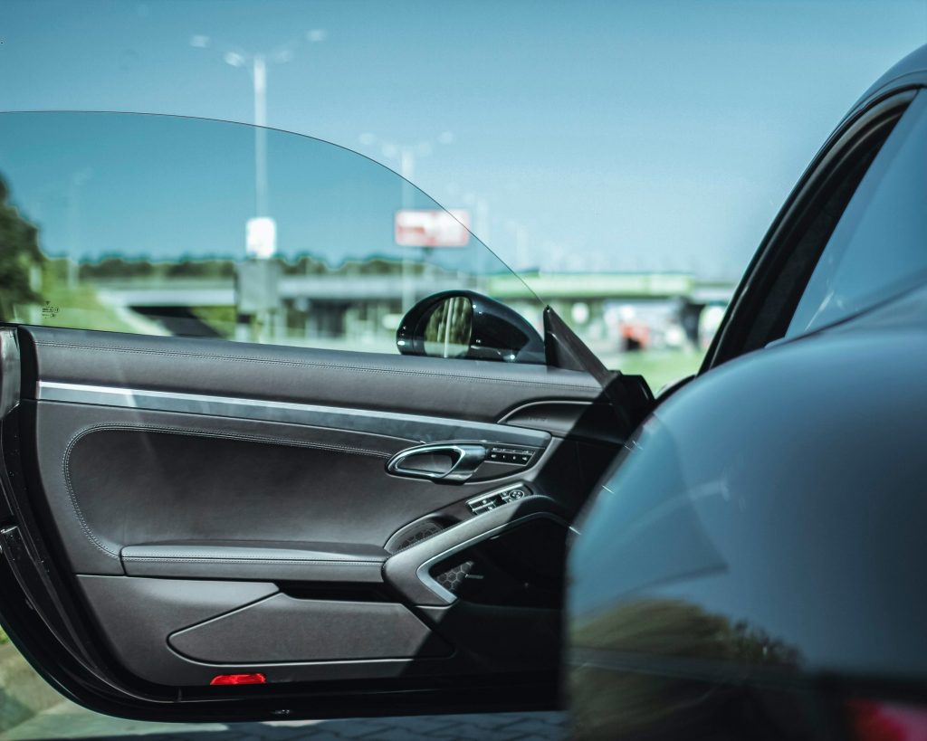 Imagem mostra a porta aberta de um carro preto