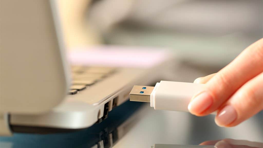 Mulher prestes a conectar pendrive em notebook