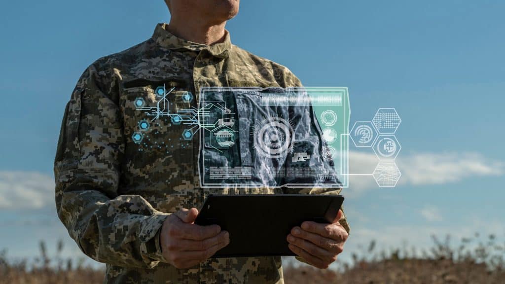 Montagem com soldado controlando drone e, em cima dele, está uma ilustração no estilo holograma