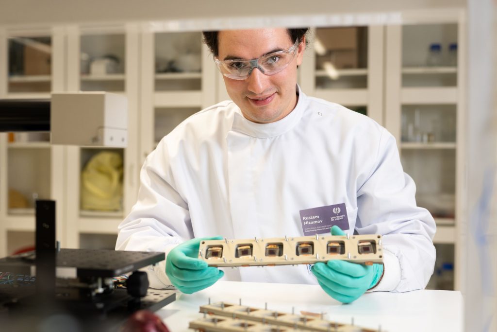 O pesquisador de doutorado Rustem Nizamov observa células solares sensibilizadas por corantes em um laboratório