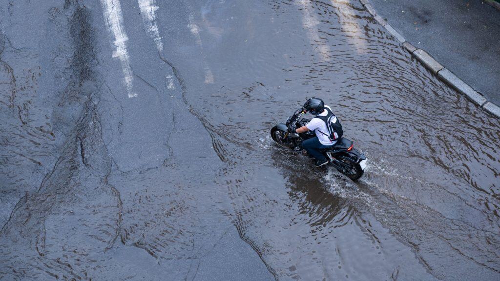 motociclista em uma area de inundação