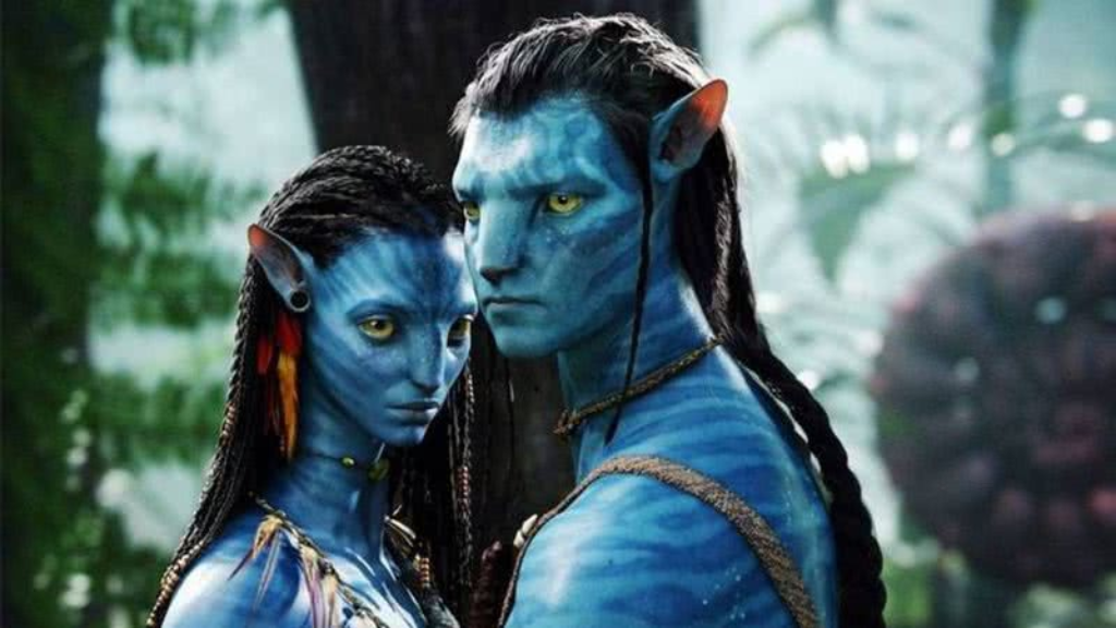 Cena do filme Avatar com dois personagens da espécie Na’vi, de pele azul e olhos amarelos, em um ambiente de floresta exuberante. Eles estão próximos, com expressões sérias e detalhes tribais no rosto e vestimentas.