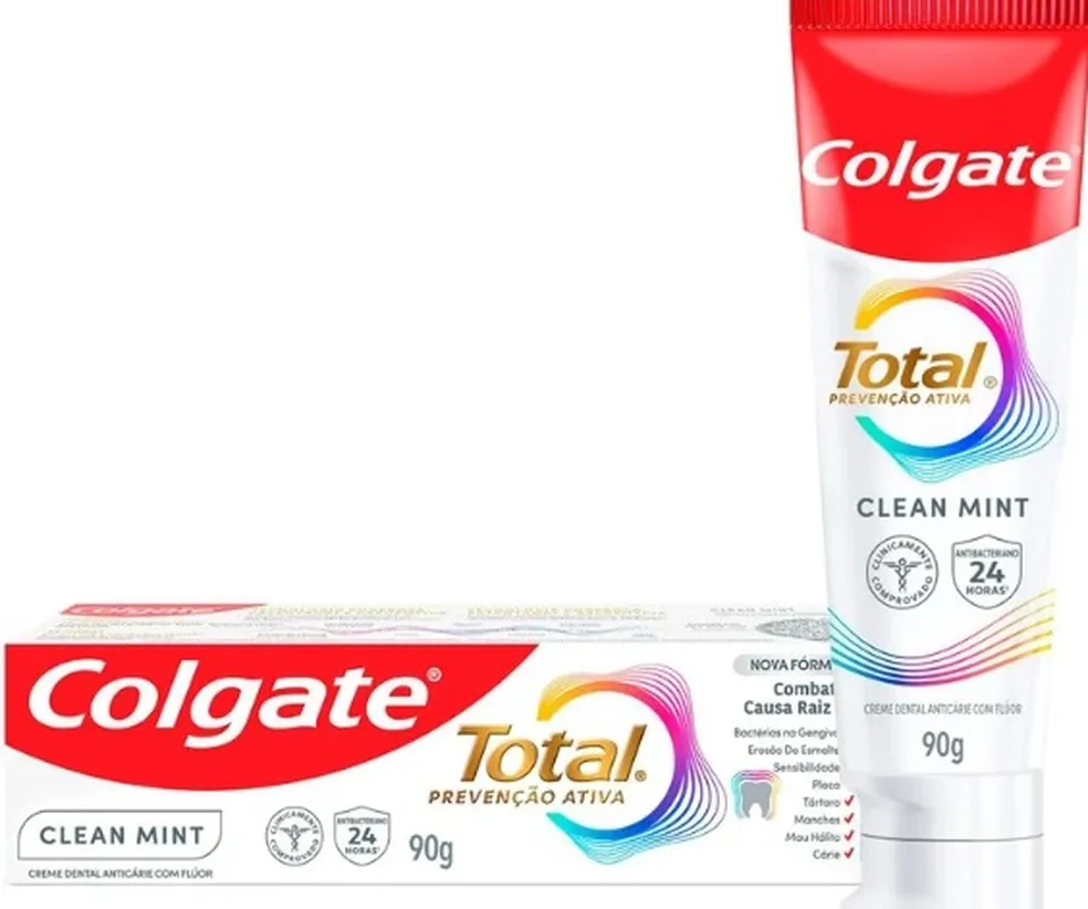 Caixa do creme dental da Colgate deitada; à direita, em pé, o creme dental