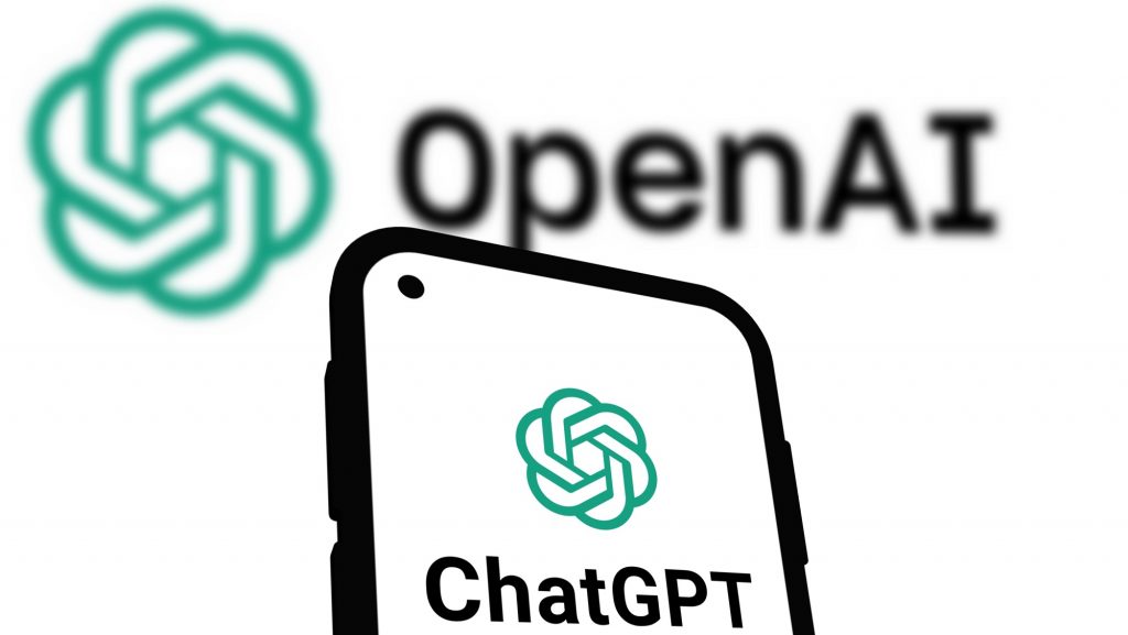 Logomarca do ChatGPT em tela de celular colocado na frente de imagem de logomarca da OpenAI