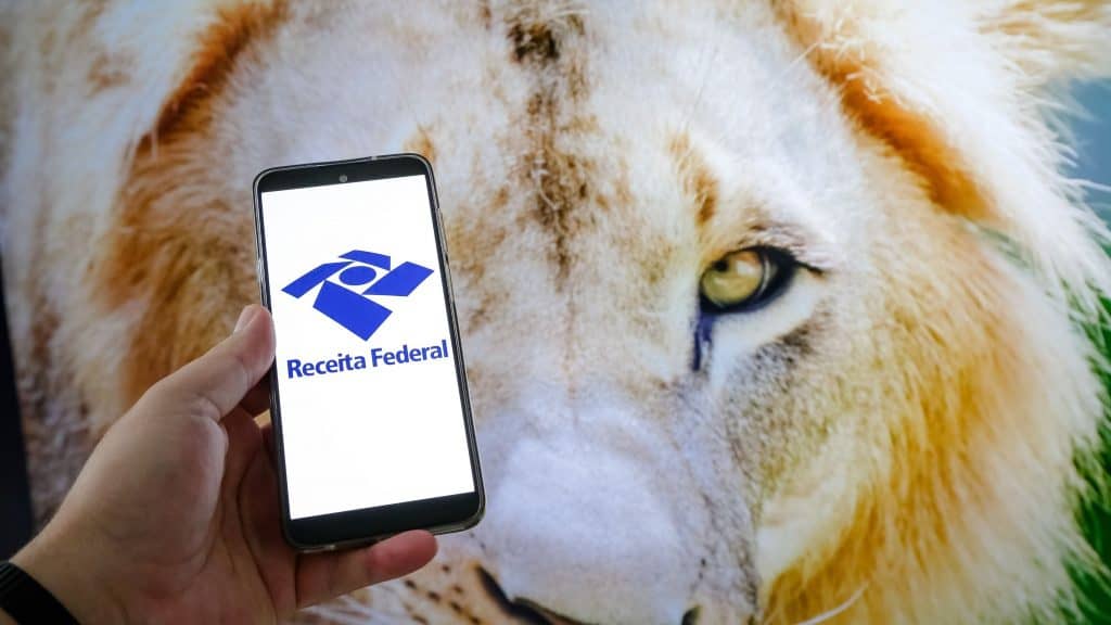 Nesta ilustração fotográfica, tela de um celular com o leão do imposto de renda federal.