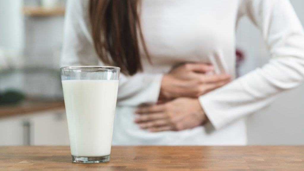 Conceito de intolerância à lactose. Mulher com dor de estômago devido à intolerância à lactose.