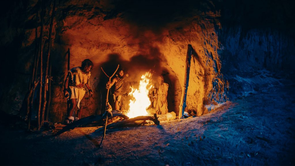 Homens das cavernas em volta de fogueira