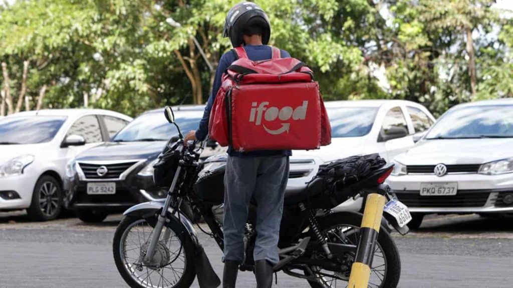 Entregador do Ifood de costas e com moto
