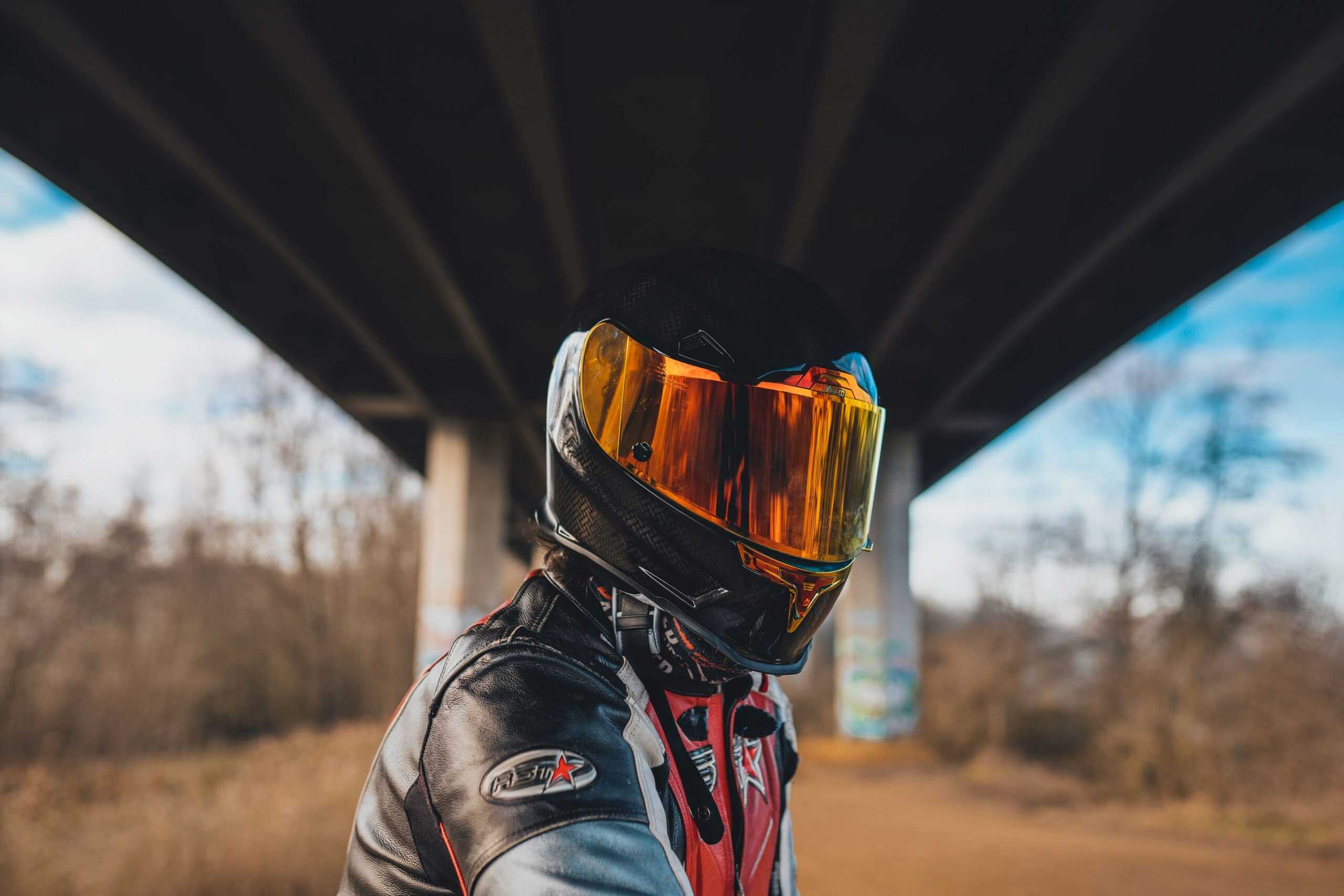 Motociclista com capacete e viseira laranja