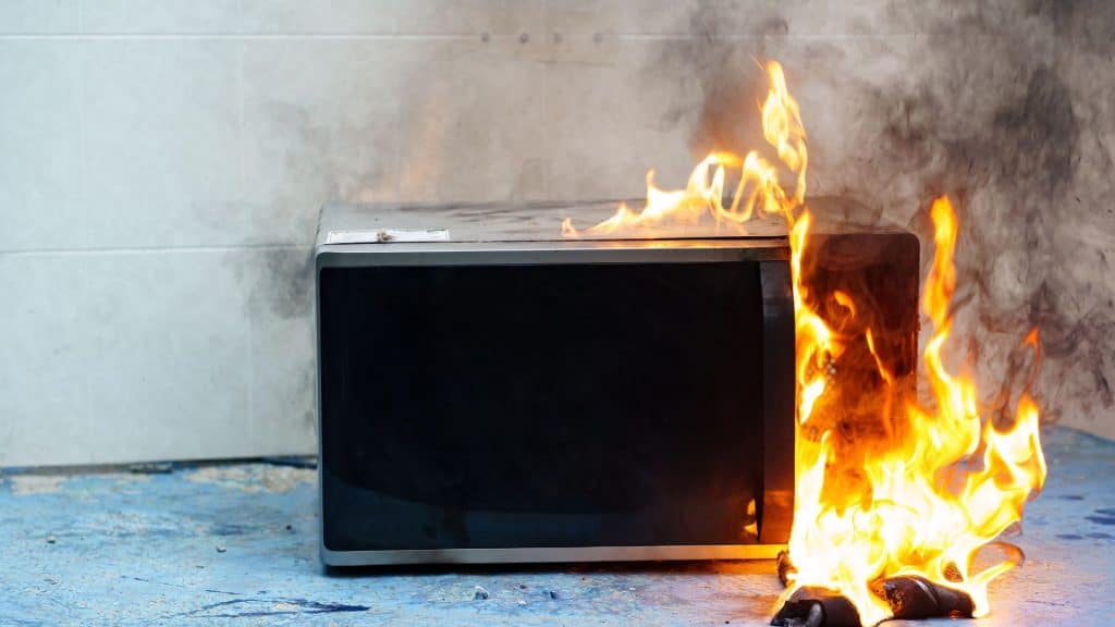micro-ondas em chamas. o conceito de incêndio na cozinha e mau funcionamento, avarias de eletrodomésticos e fiação, instalação de sistemas de segurança contra incêndio.