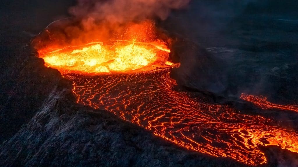 Caldeira de vulcão cheia de lava borbulhante e escorrendo durante erupção