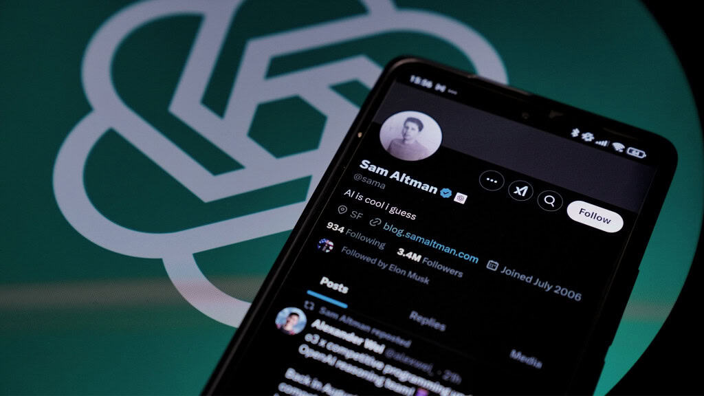Celular com página de Sam Altman, CEO da OpenAI, no Twitter aberta, colocado na frente de tela exibindo logotipo da OpenAI