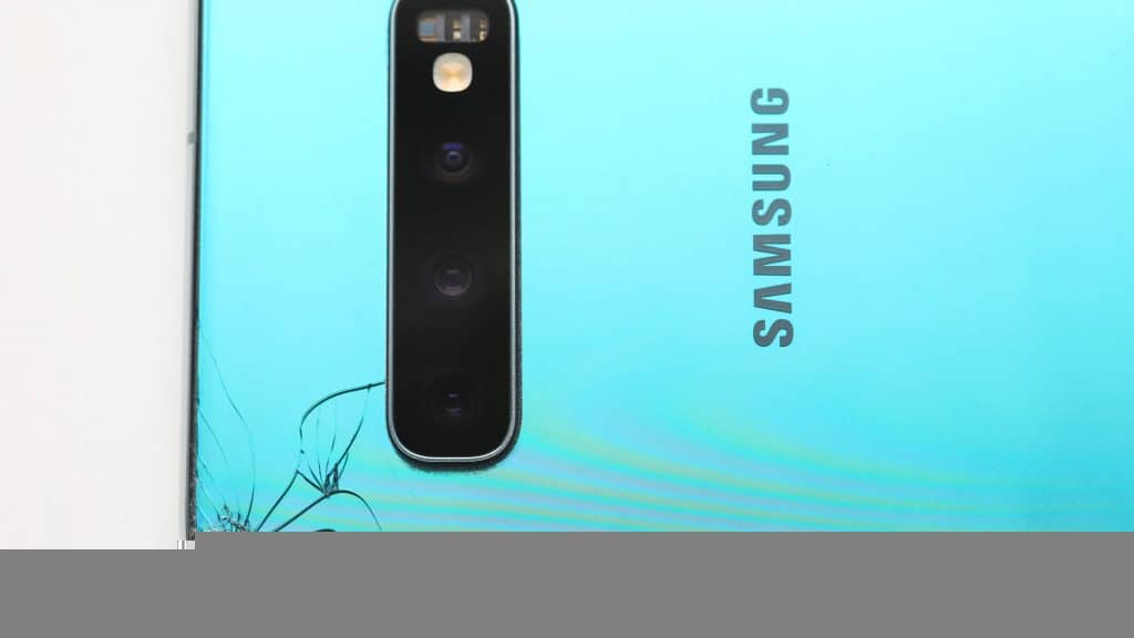 imagem mostra a traseira azul metálica quebrada em um celular da samsung