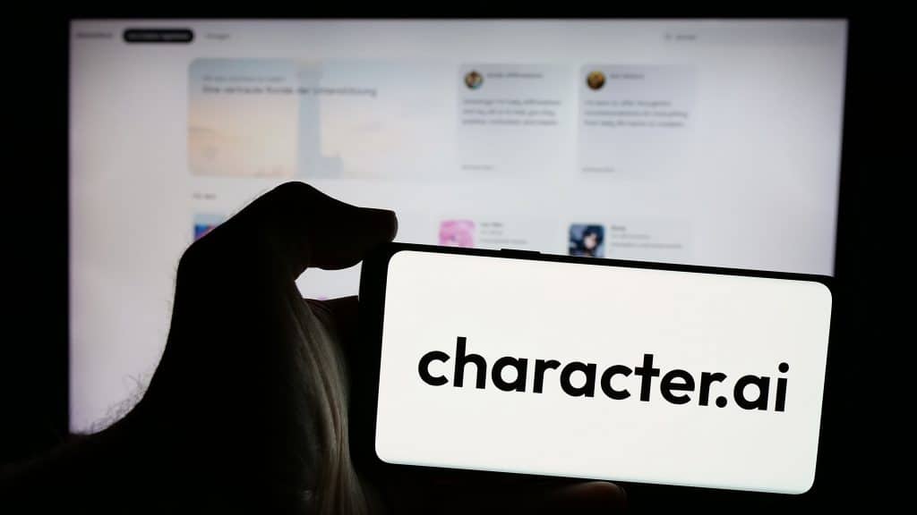 Pessoa segurando smartphone com logotipo da Character Technologies Inc. (Character.ai) na tela em frente ao site. C