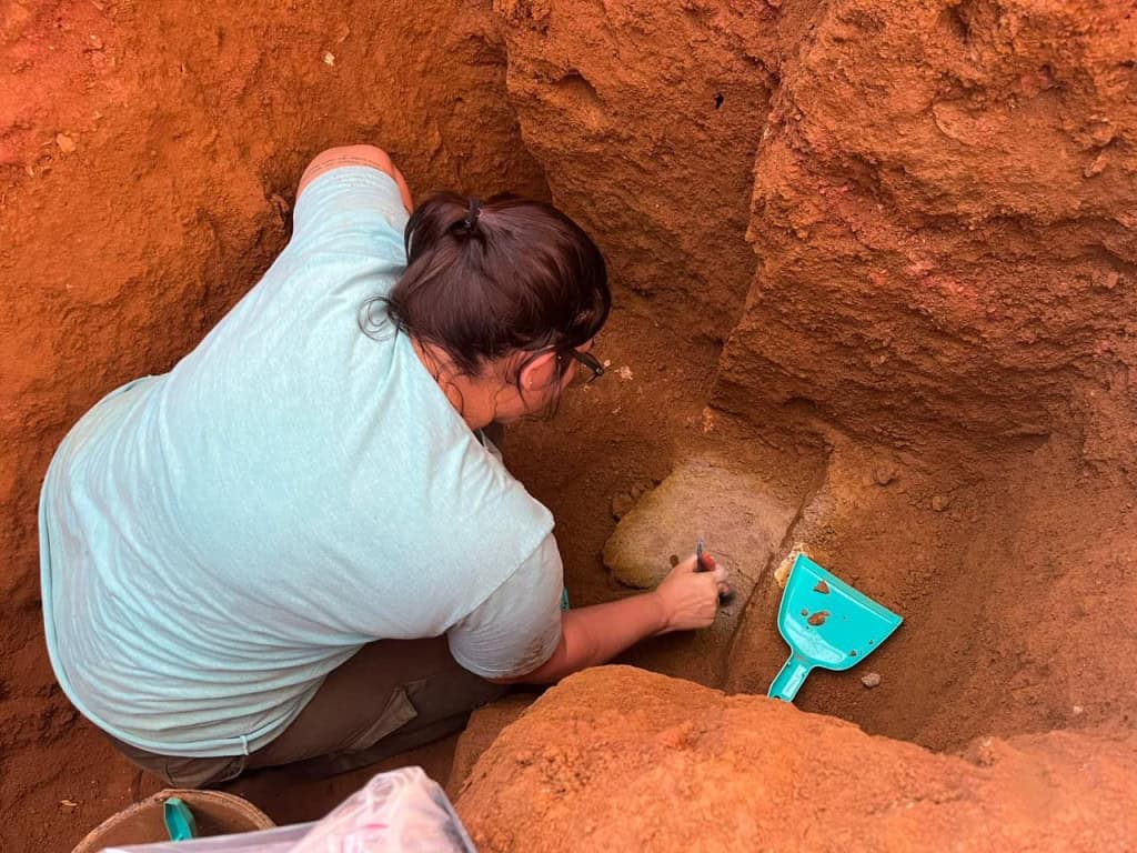 Mulher escavando parte baixa de um buraco