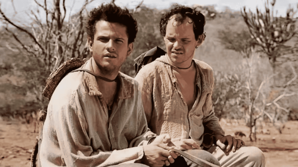 Dois homens com roupas simples e desgastadas estão sentados em uma paisagem seca do sertão. Um deles segura um facão, e ambos têm expressões de preocupação enquanto olham para algo fora do quadro.