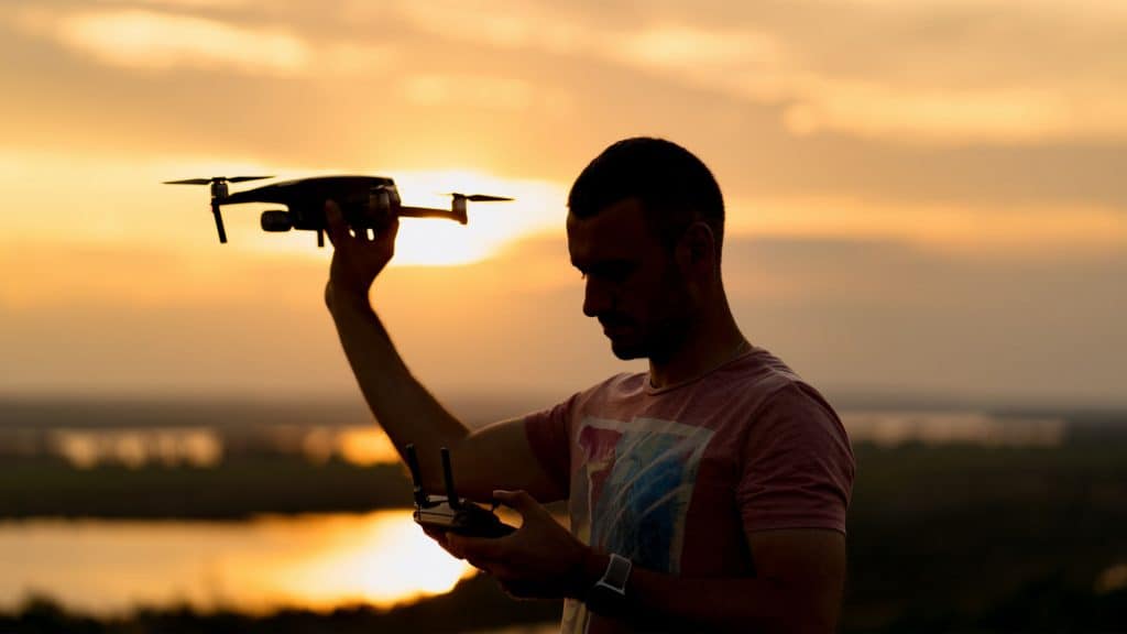 Pessoa na sombra segurando um drone