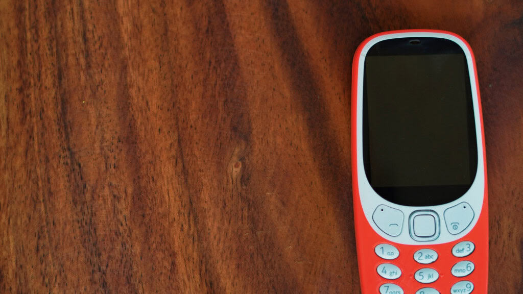 Celular laranja em cima de mesa