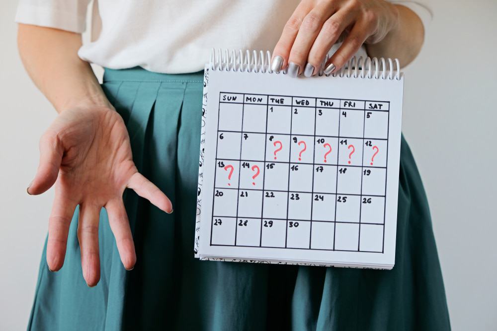 Mulher segurando um calendário em frente ao corpo