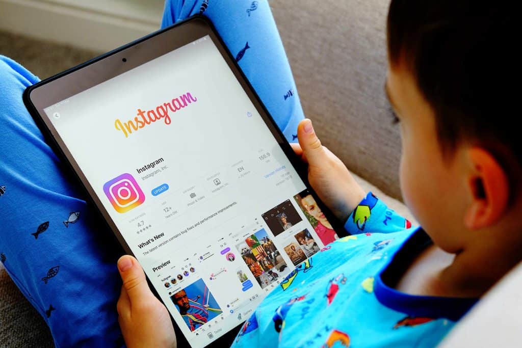 Criança mexe em aplicaivo do Instagram no tablet