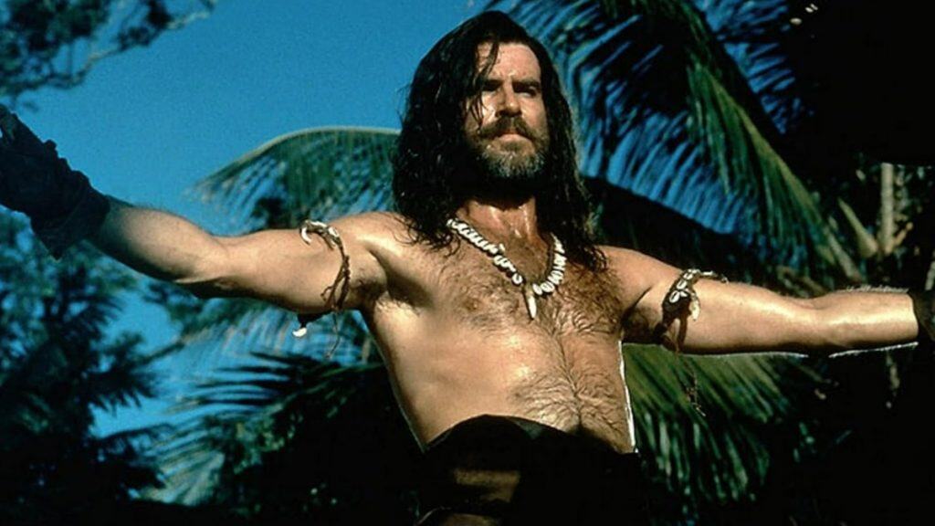 imagem mostra o personagem principal sem camisa e com roupas improvisadas no meio da mata
