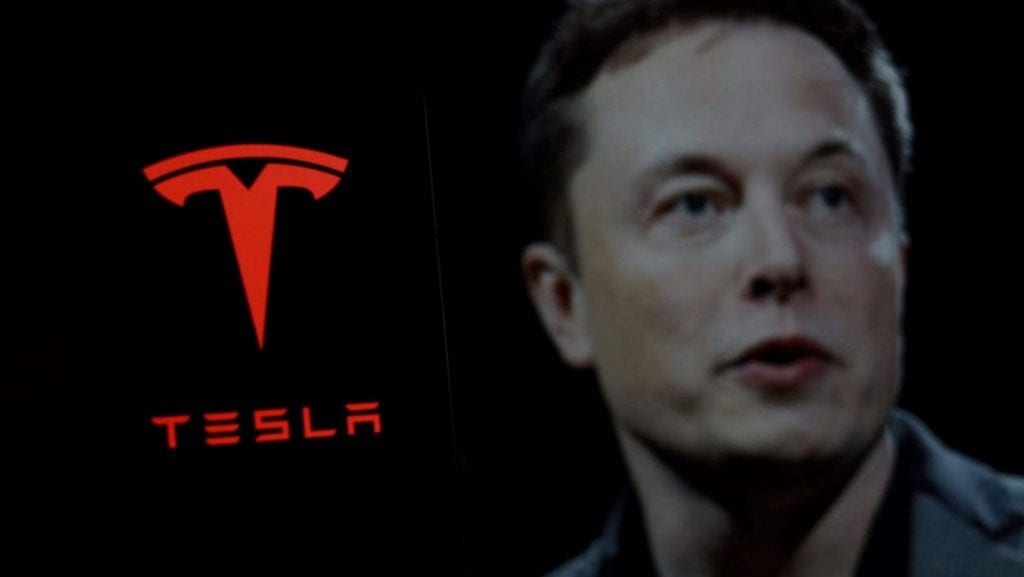 Logo da Tesla ao lado da foto de Musk