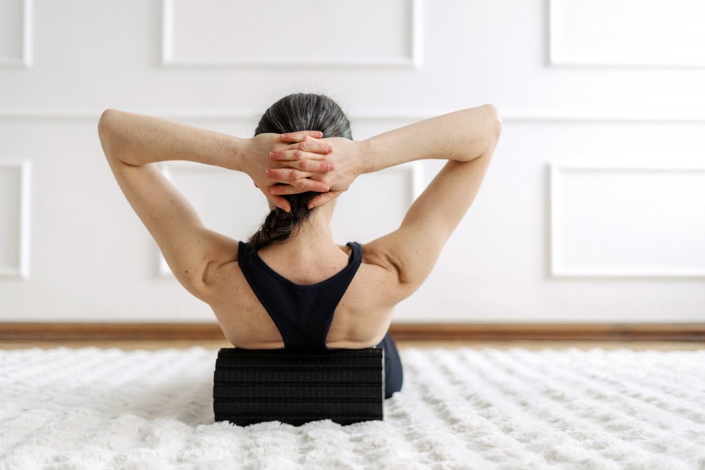 Mulher de costas fazendo exercícios abdominais