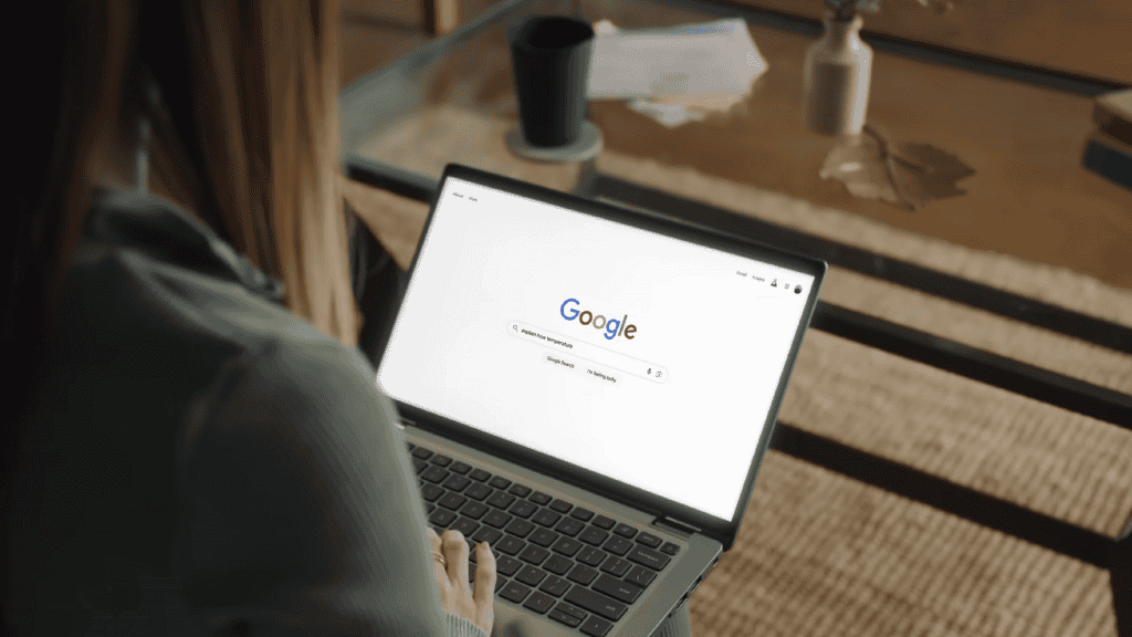 Mulher de costas realizando uma pesquisa no Google em um notebook