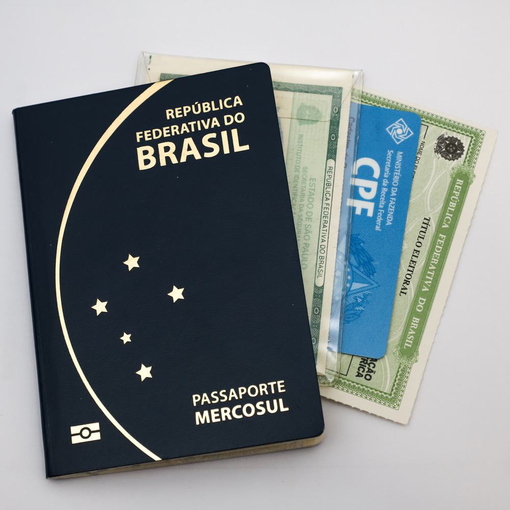 Passaporte brasileiro, carteira de identidade, CPF e registro de eleitor em fundo branco
