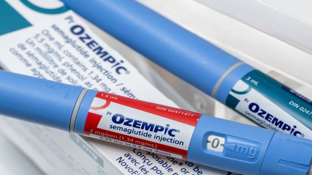 Canetas e caixa de injeção semaglutida Ozempic. Ambas tem cor azul e logo com partes vermelha e azul.