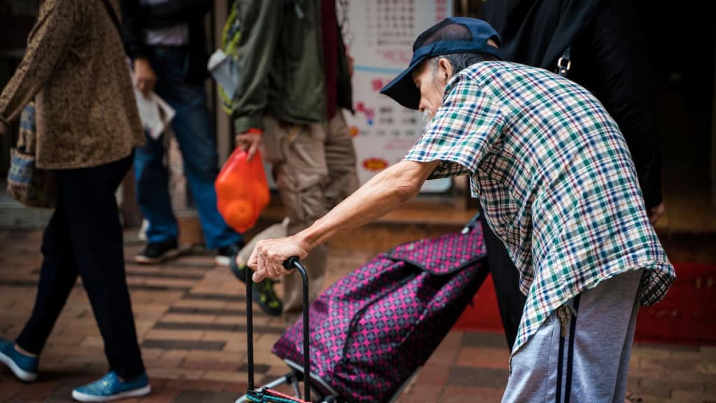 Idoso com hipercifose, doença que deixa as costas curvadas na velhice
Jordânia, Hong Kong - 5 de novembro de 2018: Homem idoso caminhando pelas ruas da cidade de Hong Kong