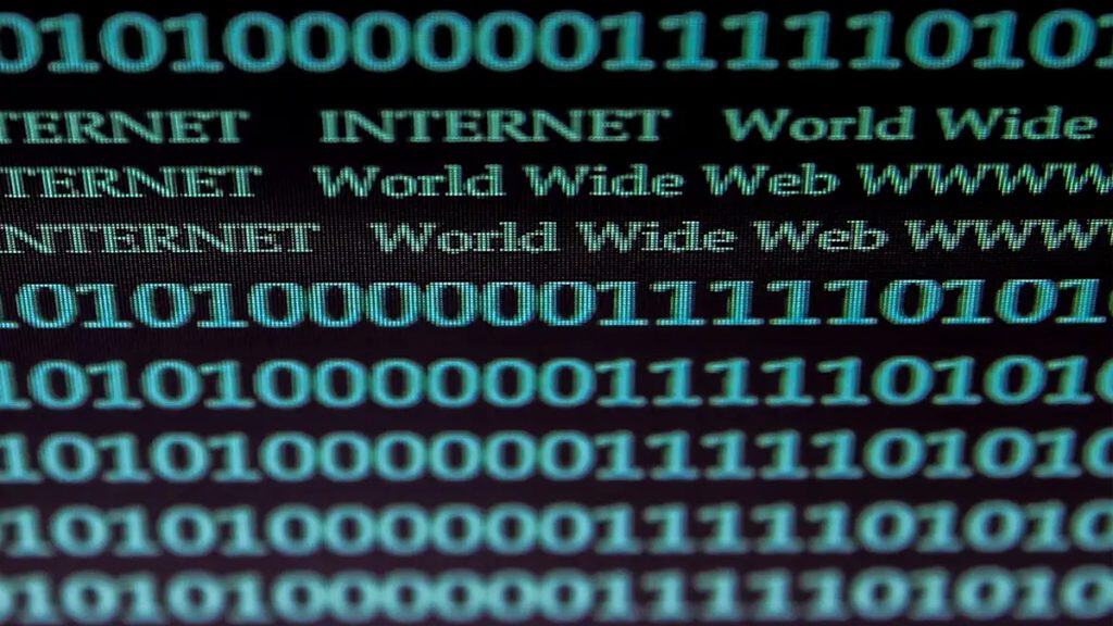 Linhas de código binário em tela de computador para ilustrar conceito de internet