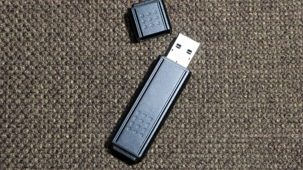 Pendrive destampado sobre um tapete, ou banco de carro