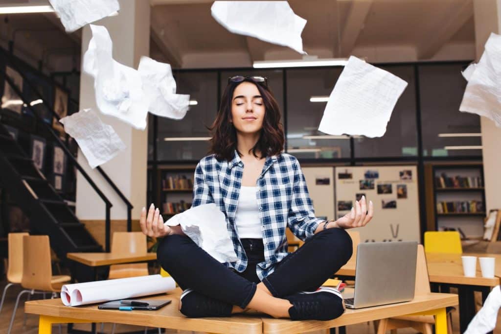 Mulher meditando em um ambiente de trabalho estressante
