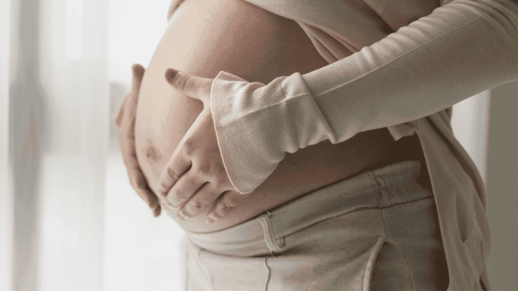 Mulher grávida com as mãos em sua barriga
