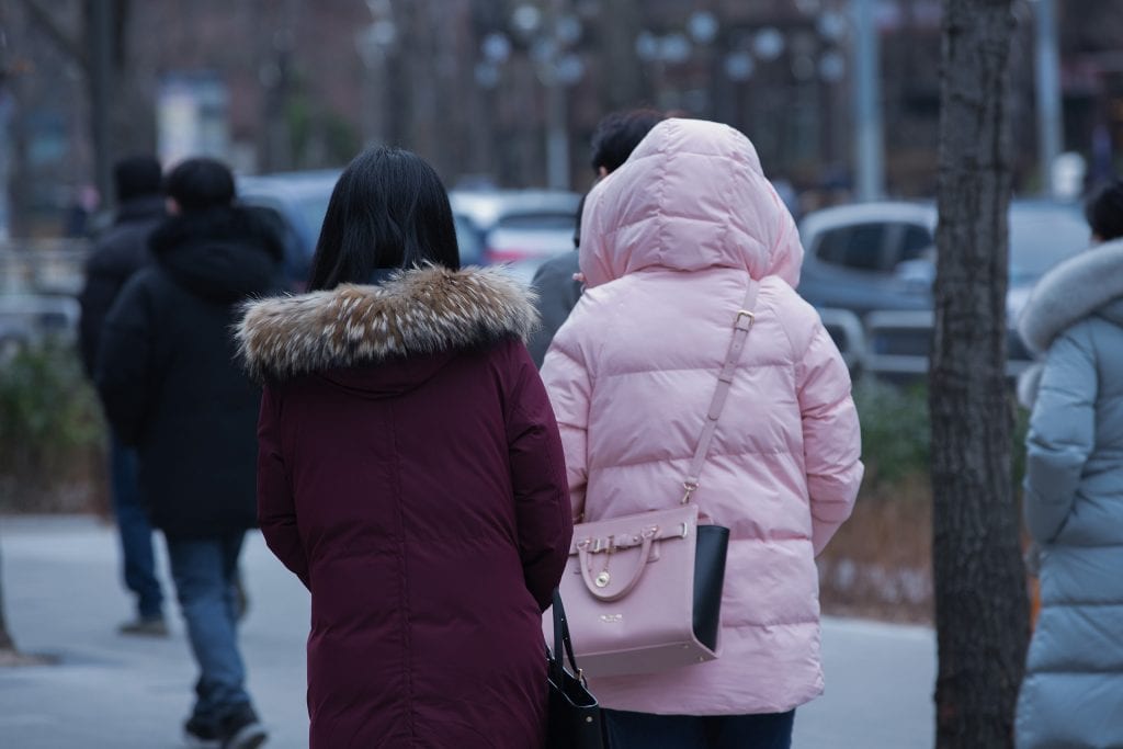 Duas mulheres de costas e com blusas de frio