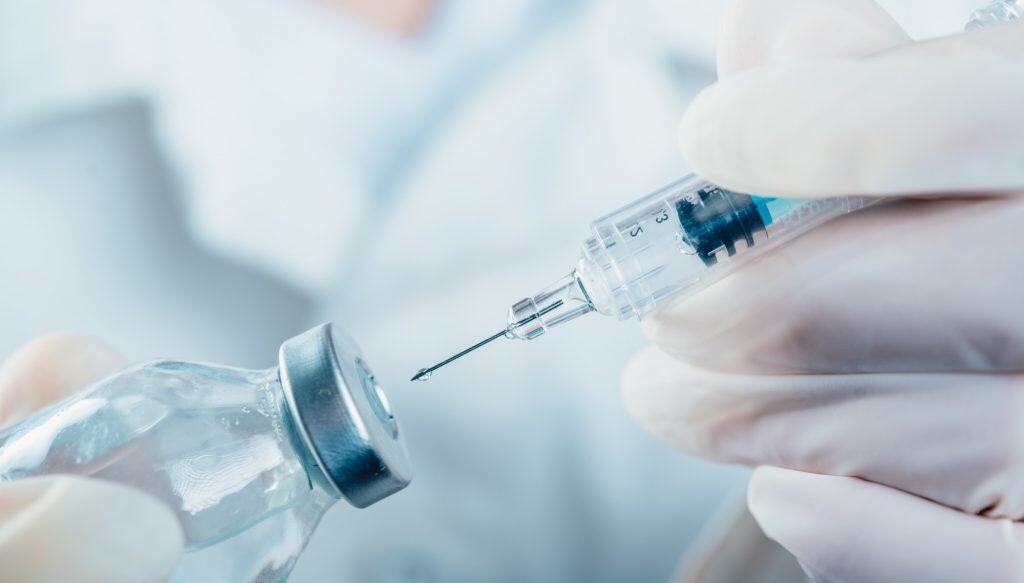 Médico segurando uma seringa com um frasco de vacina